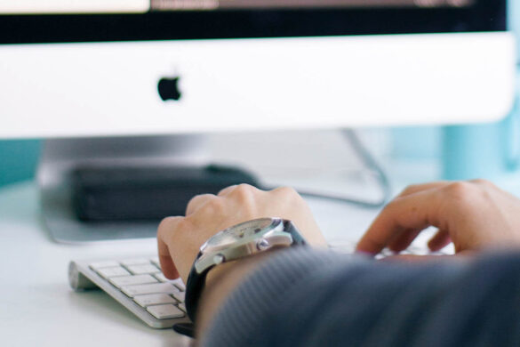 Hands on keyboard at a trading workspace setup, with financial charts on multiple monitors, creating an optimal trading environment.